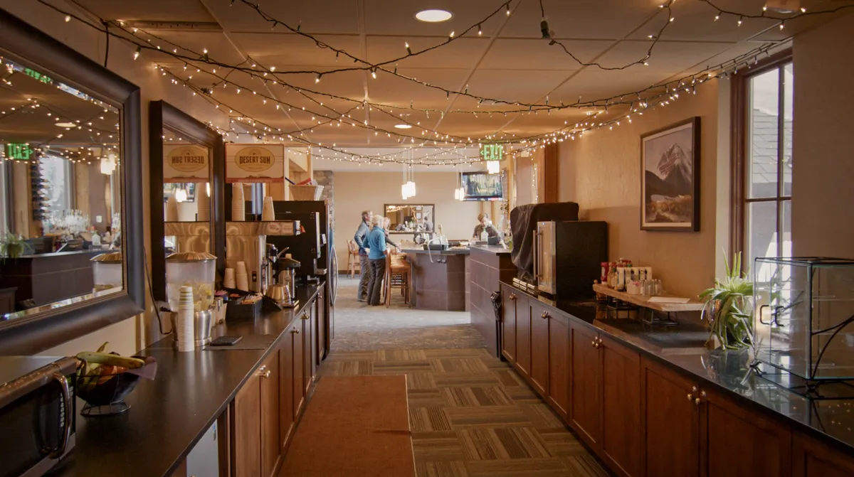 A welcoming bar and coffee station with decorative lights, art, and a relaxed ambiance. This area is perfect for morning coffee rituals or evening drinks, reinforcing the social and communal aspect of the mountain home.